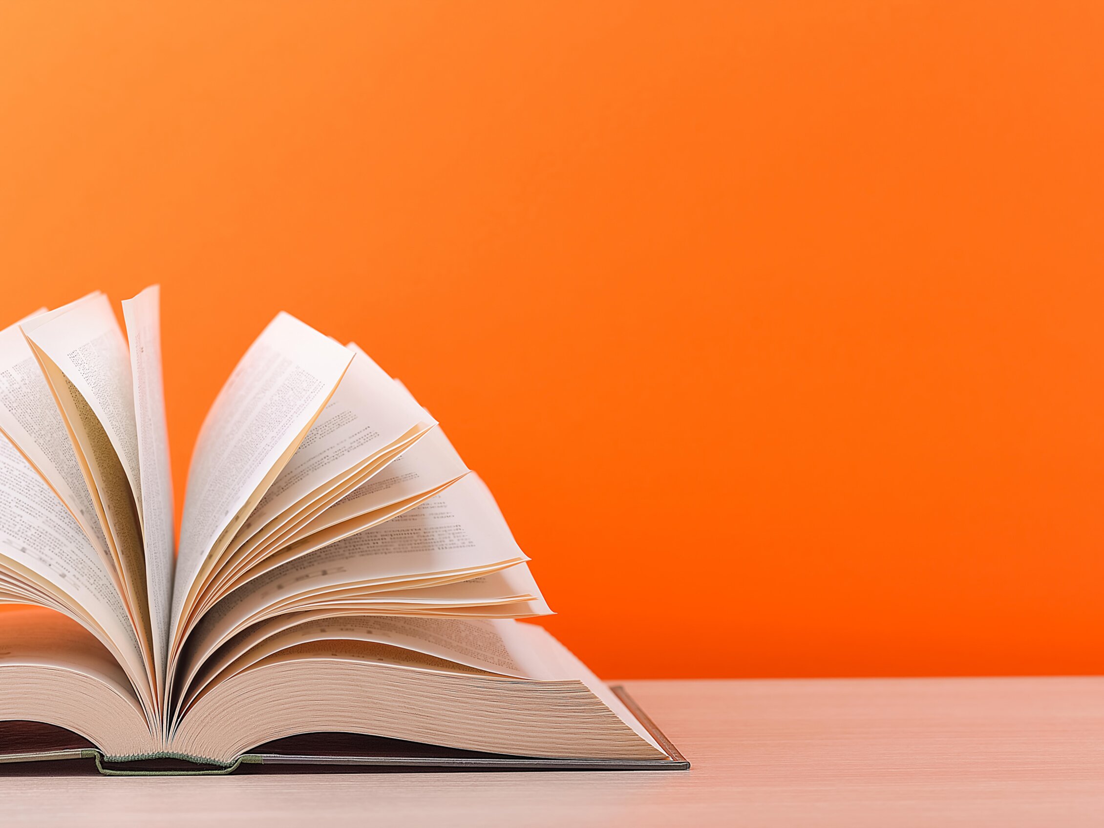 un libro aperto su sfondo arancione